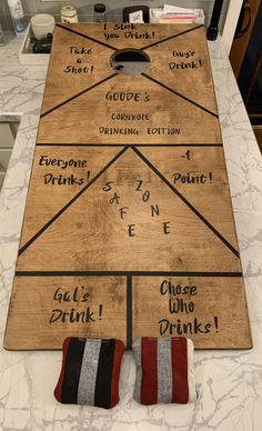 a large wooden board game sitting on top of a counter next to two wine glasses