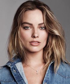 a woman with blonde hair and blue denim shirt posing for a magazine cover photo shoot