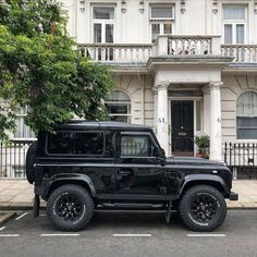 a black jeep parked in front of a white building