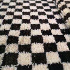 a black and white checkered blanket laying on top of a bed