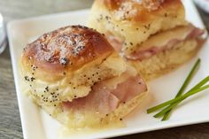 two ham and cheese rolls on a white plate