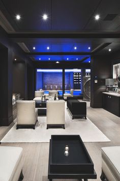 a living room filled with lots of white couches next to a kitchen and dining area