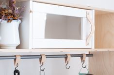 a white microwave oven sitting on top of a wooden shelf