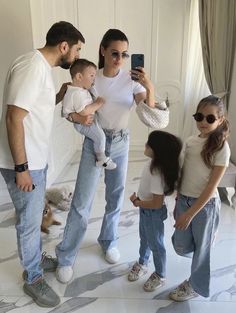 a man taking a photo with his family in front of the mirror while he takes a selfie