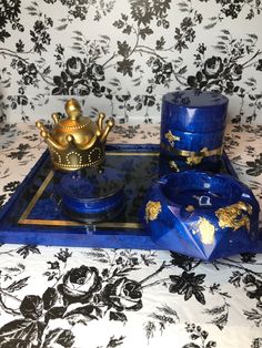 there is a blue tray with gold decorations on it and a golden tea set in the middle