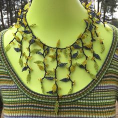 Vines and Leaves Enchanted Autumn Forest Statement Necklace Handcrafted in Eco-friendly Glass beads. The Perfect  Fall Wedding Jewelry or Bridesmaid Gift. *The beaded base is black and the tiny leaves are a chartreuse green, metallic grey and citrus yellow, all accented with larger seed beads. *The Necklace is 18 inches around and can be adjusted to 20 inches around using one of the three balls for closure. *Each Necklace comes Elegantly Gift Boxed with Enclosure Cards. Handmade Green Bridal Necklace For Party, Elegant Bead Cap Necklaces For Festivals, Elegant Festival Necklace With Bead Caps, Elegant Necklace With Bead Caps For Festivals, Elegant Yellow Beaded Necklaces With Tiny Beads, Elegant Yellow Jewelry With Tiny Beads, Handmade Yellow Necklaces For Wedding, Bohemian Yellow Necklaces For Wedding, Elegant Glass Necklace For Festivals