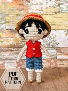 a crocheted doll with a straw hat and red shirt is standing on a wooden floor