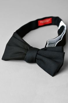 Our bowtie features a narrow squared end, for a slim overall profile and a modern, yet classic feel. We've designed it to pair perfectly with our slim-cut tuxedo or dinner jacket. We offer this bowtie in two versions: self-tie (you tie it yourself), or pre-tied (the bow is already permanently tied). Please select your preference from the dropdown menu. DETAIL & CARE: Color: Black, in a lightweight tropical wool, which coordinates well with our black tuxedo, or your own. This black wool bowtie pairs perfectly with eveningwear, typically with a tuxedo or dinner jacket. Can also be worn with a suit. 100% Wool Woven in Italy Blade Width: 1 3/4" (narrow, but not too skinny) Neck Size: Adjustable neck. Accommodates neck sizes 13 3/4" to 18 1/2" Handmade in the USA Grooming Shop, Best Umbrella, Dinner Jacket, Shorts Sweatpants, Tuxedo Shirts, Black Tuxedo, Suits For Sale, Tailored Shirts, Shirt Sale