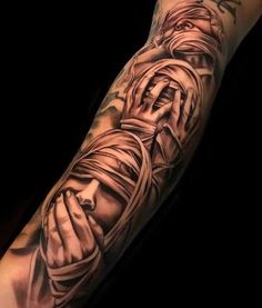 a man's arm covered in tattoos with the image of jesus holding his hands together