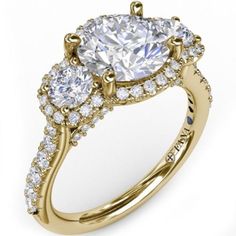 an engagement ring with three stones on the side and two rows of diamonds around it