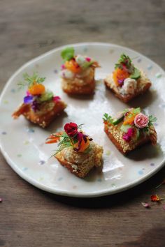 small appetizers are arranged on a plate with confetti and sprinkles