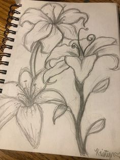 a drawing of some flowers on a table with a pen and paper next to it