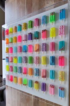 an array of popsicles are arranged on a wall