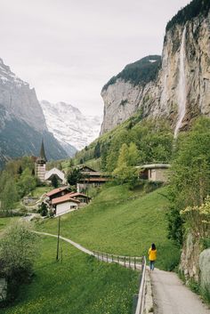 a woman walking down a path in the mountains with text overlay that reads lauterbrunnen