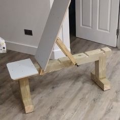 a wooden easel sitting on top of a hard wood floor next to a door