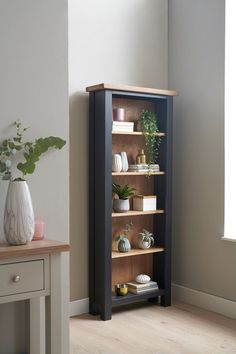 a book shelf with plants and books on it