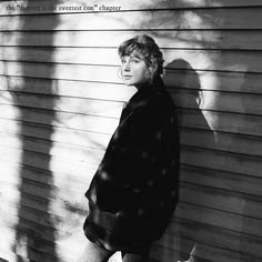 a woman standing in front of a wall with her shadow on the wall behind her