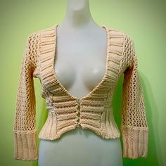 a white mannequin wearing a beige knitted cardigan