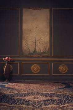 a vase with flowers sitting on top of a rug in front of a wall painting