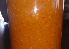 a jar filled with orange liquid sitting on top of a table