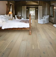 a bedroom with wood floors and white furniture