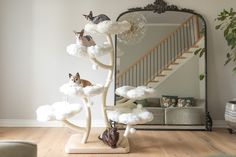 a cat statue sitting on top of a wooden stand in front of a large mirror