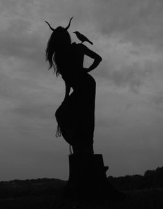 the silhouette of a woman with horns on her head is shown in black and white