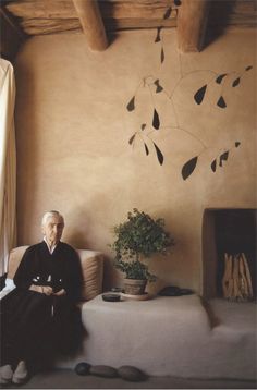 an old man sitting on a couch next to a plant