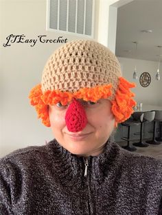 a woman wearing a crocheted hat with an orange nose