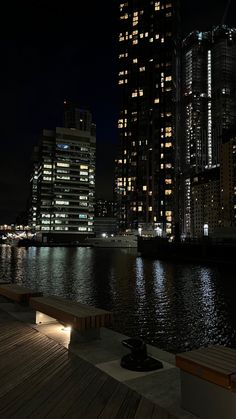 the city is lit up at night by the water