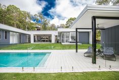 a house with a swimming pool in the middle of it's yard and covered patio area