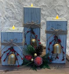 three wooden blocks with bells and pine cones tied to them, sitting on a table