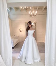 a woman in a white wedding dress is taking a selfie