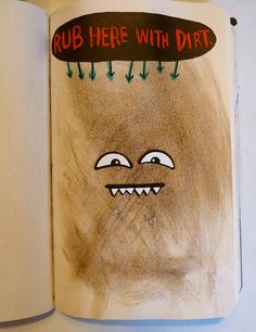 an open children's book with a drawing of a monster in the middle and words that read, rub here with dirt