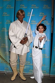 two people dressed up as luke and princess leion in front of a blue backdrop