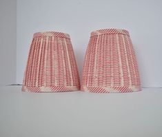 two red and white lampshades sitting next to each other