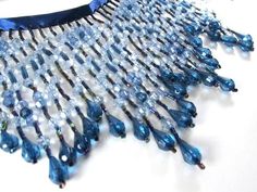 a blue and clear beaded necklace on a white surface