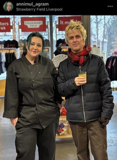 a man and woman standing next to each other in front of a store display case