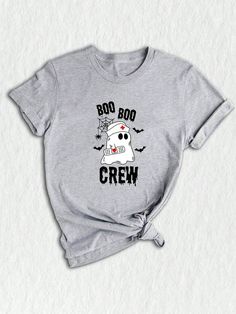 ‍⚕️ Introducing our adorable Halloween Nurse T-shirt - the perfect addition to your spooky season wardrobe!  This Nurse Shirt is designed for all the hardworking nurses out there who are ready to embrace the Boo Boo Crew and celebrate Halloween in style.  Featuring a playful and cute Halloween theme, this Spooky Season Shirt showcases a ghostly Boo with a nurse's hat and stethoscope.  The Boo Shirt is vibrant and eye-catching, making it a must-have for anyone in the nursing profession who wants Halloween Novelty Tops With Funny Text, Funny Halloween Tops With Text, Funny Halloween T-shirt With Letter Print, Halloween Crew Neck Top With Funny Text, Halloween Novelty Shirt With Letter Print, Novelty Halloween Shirt With Letter Print, Spooky Crew Neck Shirt With Letter Print, Casual Gray Tops For Halloween, Funny Halloween Tops With Character Print