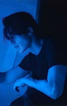 a woman sitting in front of a laptop computer on top of a blue light floor