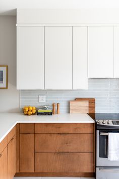 a kitchen with wooden cabinets and white counter tops is pictured in this image, there are lemons on the counter