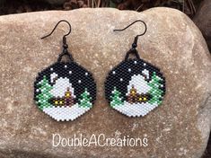 a pair of black and white beaded earrings with an angry bird on the front