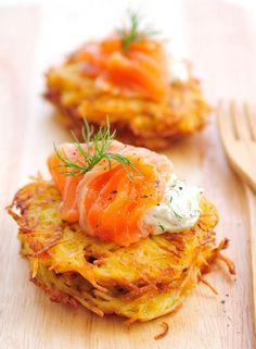 some food that is on top of a wooden cutting board next to a fork and spoon