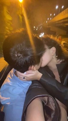 two people are kissing in the back of a car