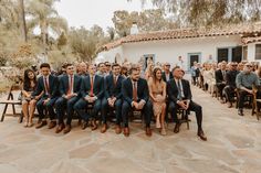 a group of men and women sitting next to each other in front of a building