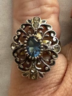 Beautifully crafted filigree sterling silver ring with lovely dark blue center crystal. Additional highlight rhinestones at 12-3-5-9 with doubles at 12 & 6. I believe the stones are crystals. the center stone at least is unfoiled. They may be glass and the price reflects glass indeed being the stones. I love the boho styling and the statement size. It fits my pinky, but on your ring finger, it's not smaller. In excellent condition with no signs of wear. Beautiful.  Please review all photos carefully. They do constitute a large portion of the description.  Measurements are approximate: size: US 5.5 Length:  1" Width:  3/4" Please note monitors display colors differently.  Thank you for looking. I am most grateful. Please check in often for new and interesting items.  You never know what mig Vintage Sterling Silver Rings, Sterling Silver Filigree, Boho Stil, Silver Filigree, Ring Finger, Ring Sterling Silver, Blue Crystals, Sterling Ring, Rings Statement