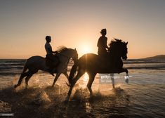 two people are riding horses on the beach at sunset stock photo getty images black bedroom furniture sets home design ideas