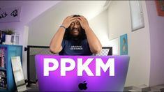 a man sitting in front of a laptop computer with the words ppkm on it