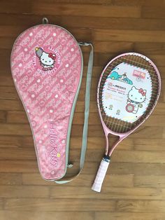 the hello kitty tennis racket is laying on the floor next to it's case