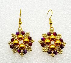 Absolutely gorgeous! That's what you will hear when you wear these stunning earrings! They were hand woven using gold pearls that are surrounded by garnet crystals and gold accent beads that form beautiful flowers. They are perfect for any formal event, or to dress up an every day outfit. They hand from hypoallergenic ear wires and come carded with stoppers. Festive Gold Beaded Pearl Earrings, Elegant Red Earrings With Gold Beads, Party Gold Beaded Pearl Earrings, Gold Beaded Flower Earrings For Party, Gold Beaded Pearl Earrings For Celebration, Handmade Gold Crystal Earrings For Festive Occasions, Festive Handmade Gold Crystal Earrings, Gold Handmade Cluster Earrings For Party, Garnet Crystal